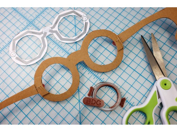 Use the template as a guide to add a piece of Maker Tape across the top of the frames, connecting the shorter, Negative legs of the LEDs.