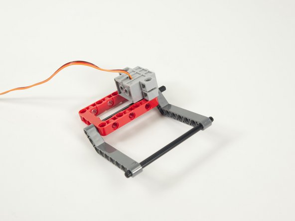 Attach the servo to the frame using the black pins we just added.
