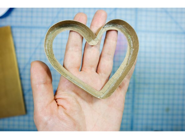 Use hot glue to adhere the strip to the exterior of the heart. Start at the point of the heart and slowly work your way around. Only apply glue to the inside to keep things tidy.