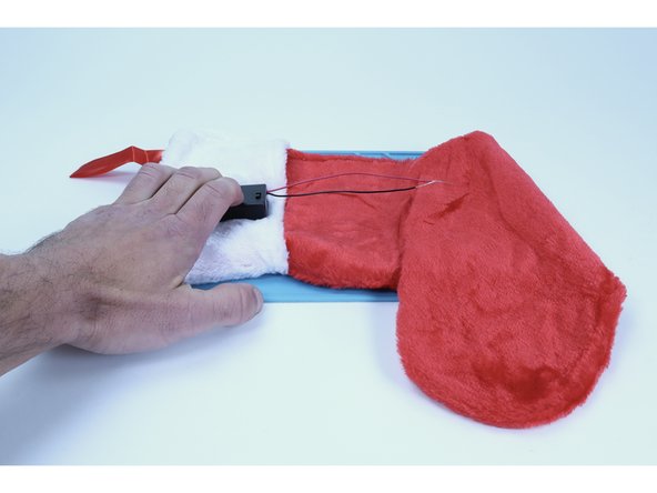 Begin by applying hot glue to a AA battery pack. 