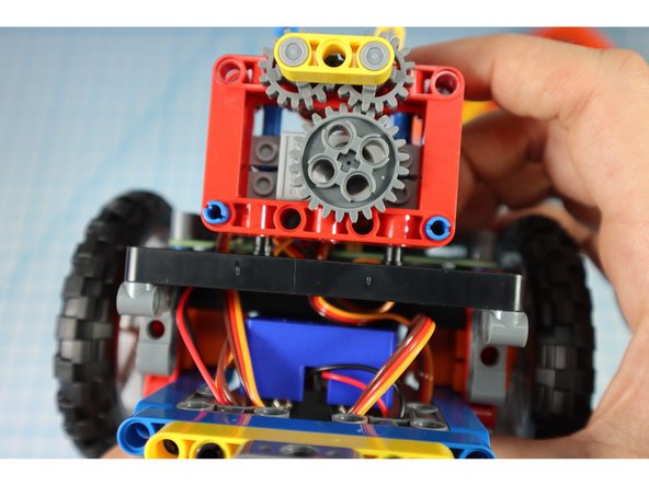 Add the arm gear assembly to the pins as shown.