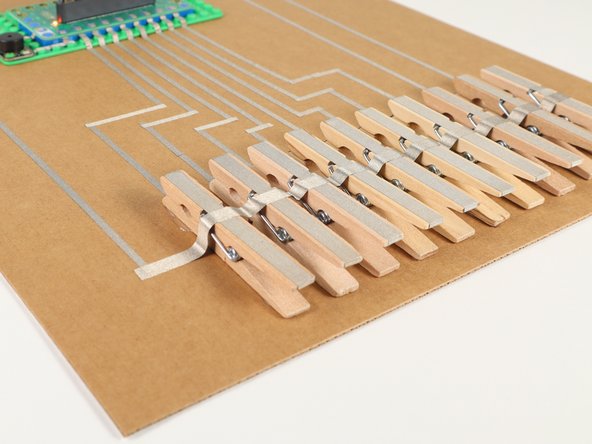 Run one long piece of Maker Tape across the top of the clothespins to the ground connection on the left side.