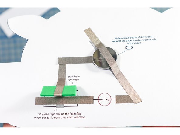 Place the battery with the positive side up. Add another piece of Maker Tape over the battery and around the bend.