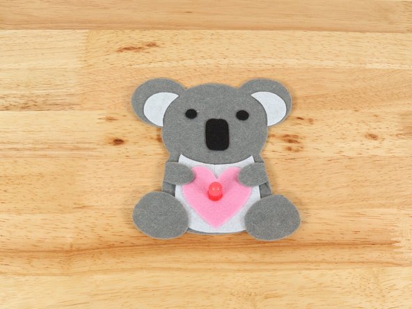 If you are using Elmers or Tacky glue, you will need to use something to hold the paws in place until it dries. Binder clips work well for this.