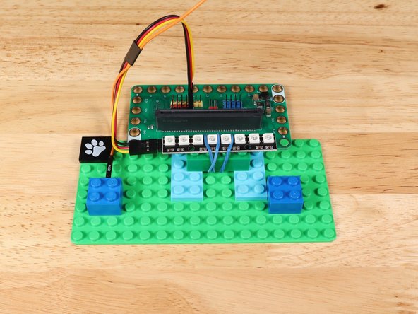 Using some bricks, connect the beam with servo attached to the baseplate.