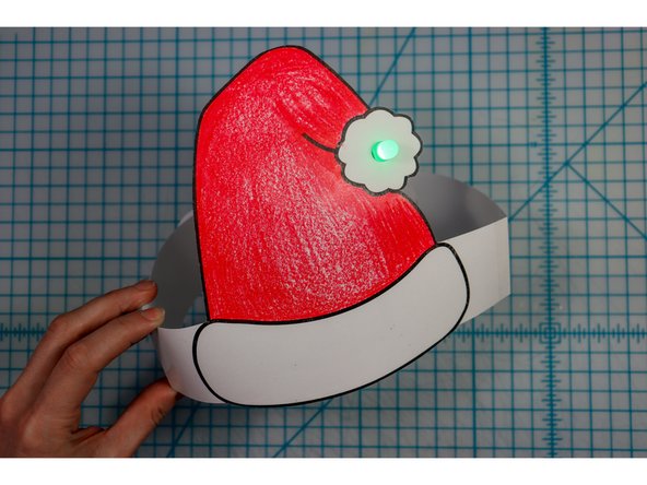 Cut out the side strips and tape them to the hat with the slits facing up on one side and down on the other.