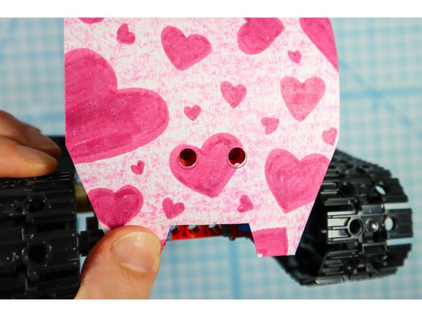 Wrap the paper over the body and use two more pin/beam sets to secure the front as shown.