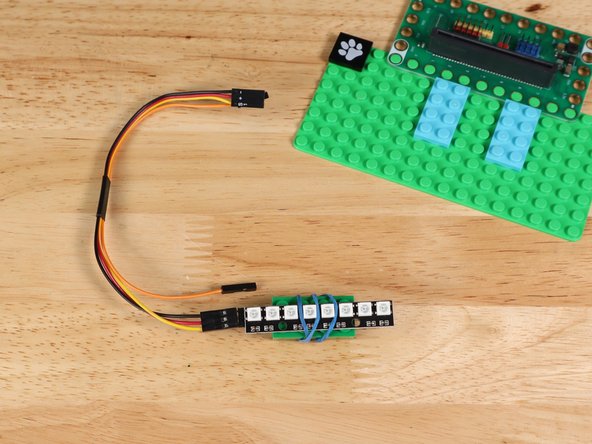 Connect the brick to a couple other LEGO parts on the baseplate so the rubber band doesn't get in the way.