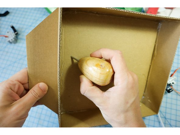 Make holes in the box to thread the motor wires through. Place the fish body on the plaque to find the correct location of the holes.