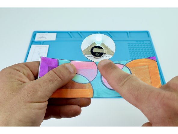 To complete the circuit and turn your LED on, peel and stick the final remaining Maker Tape section where shown in photos 2 and 3.