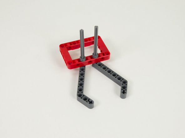 Slide two gray half bushings onto the tops of the axles and press down against the red frame.