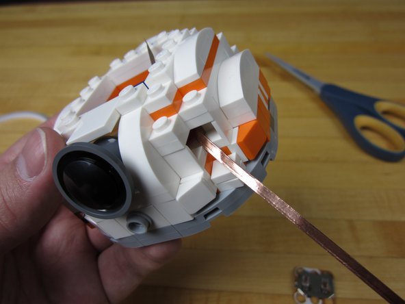 Run two lines of Nylon Conductive Tape from the outside to the inside of the head.