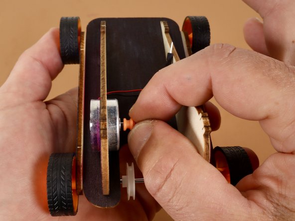 NOTE! Hopefully you've already added the small orange pulley to the motor shaft in Step 2. If you did not, you can add it now.
