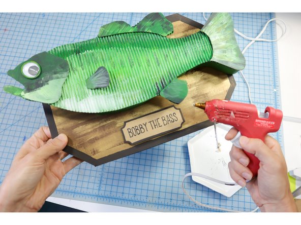 Use hot glue to adhere it to the plaque.