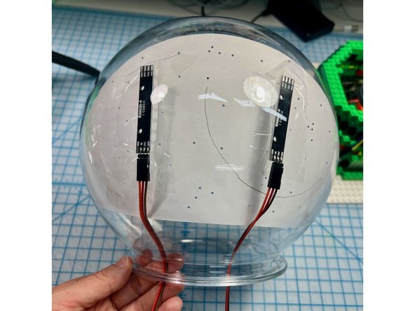 I taped NeoPixel sticks to the back and covered them with a layer of shiny blue cardstock that I punched holes out of to give the appearance of many light-up stars.