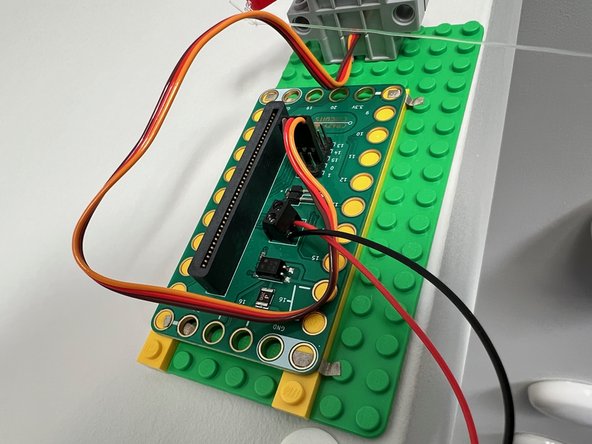 Connect the battery pack to the battery terminal, the servo motor to pin 0, and place the micro:bit into the edge connector.