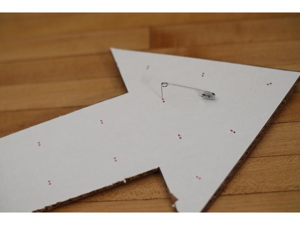 Use a large safety pin to poke holes in the arrow where indicated.