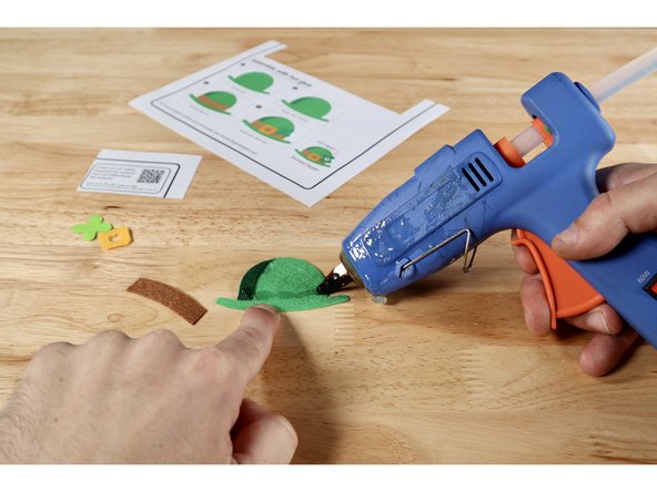 Using the step-by-step pictures on the template sheet OR these photos as a guide, glue the layers together to form the final design. The shadow goes atop the hat. The hat band goes on top of the hat and shadow. The buckle and shamrock are the topmost pieces.