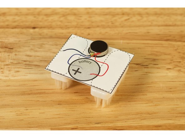 Peel the backing off of the  Self-Sticking Vibrating Disc Motor and attach it to the template.