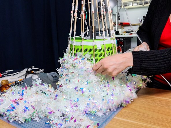 Add garland by wrapping it tightly around the tree. Look for translucent or shiny garland to diffuse and bounce the light throughout the tree.