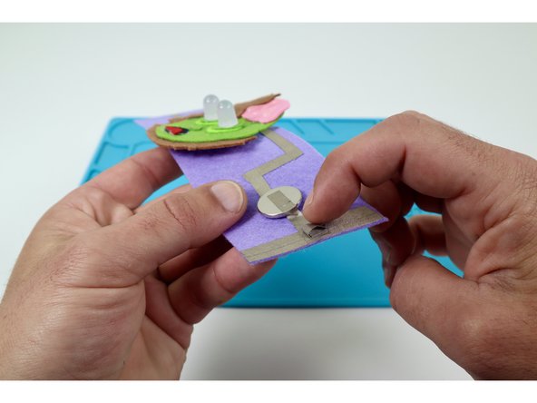 Use one of the two pieces of Maker Tape to create a tape loop (sticky-side-out) and stick it in the middle of the edge pad pictured in photo 1.