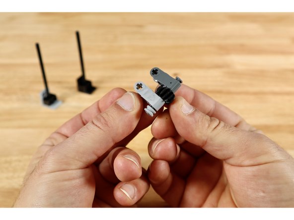 Now use 2 (1x3) cross blocks, one small axle with end stop, 1 (12 tooth) bevel gear and a half bushing to create the build in slide 2. The bevel gear should spin freely between the two cross blocks and the axle should be secured on one side with the half bushing.