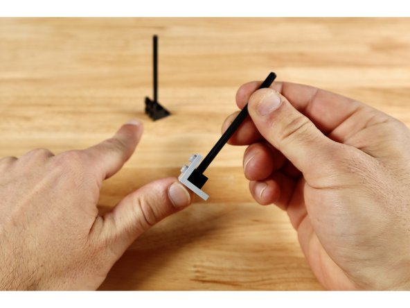 To begin the gear rack build, connect each of the (1x2) bricks with axle hole to a (2x2) 90 degree bracket as shown. Seat each of the long axles into the axle holes of the (1x2) bricks.