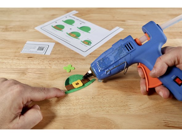 Using the step-by-step pictures on the template sheet OR these photos as a guide, glue the layers together to form the final design. The shadow goes atop the hat. The hat band goes on top of the hat and shadow. The buckle and shamrock are the topmost pieces.