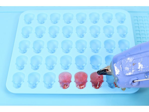 Now, with the lower portion of glue hardened, squeeze glue into the each of the mold cavities until they are filled to the top. 