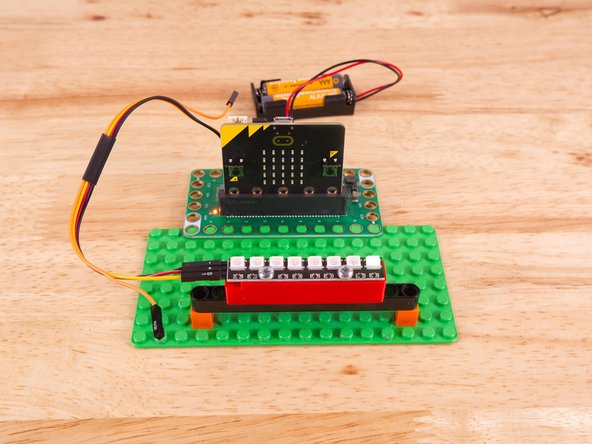 To mount the NeoPixel Stick in place we used our NeoPixel Beam Holder with a long Technic Beam and two 1x1 LEGO bricks.
