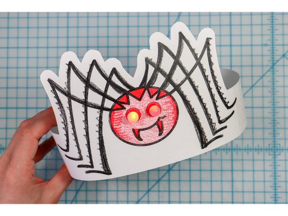 Cut out the side strips and tape them to the hat with the slits facing up on one side and down on the other.