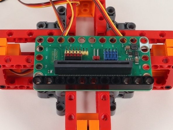 Add an 11-hole black beam onto the black pins to hold the Bit Board down.