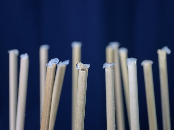 Add a glue dot or a dab of hot glue to the top of each dowel and place each dowel inside the holes on the circle piece as shown.