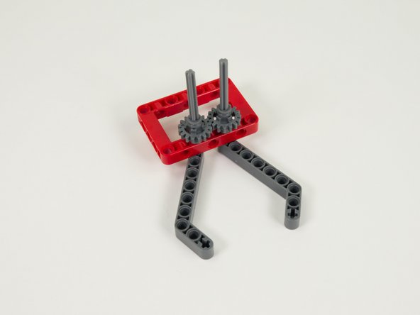 Press two more gray half bushings down onto the axles so they are touching the gears.