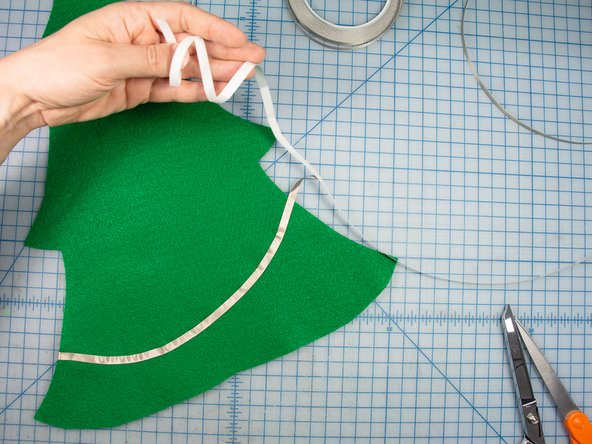 Position the tape at the bottom of the tree on the backside of the felt.