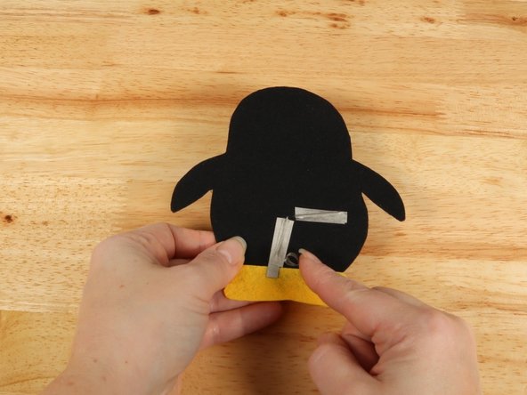 Make a loop of tape (sticky side out) using a short piece of Maker Tape, and stick it atop the end of the path coming from the short (Negative) LED leg.