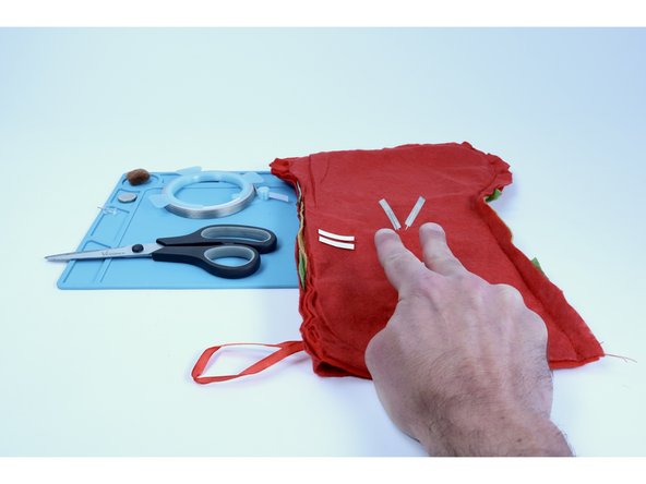 Note: The fuzzy fabric that your stocking is likely made of is an insulator &amp; can prohibit electricity from traveling through the circuit as intended. What we aim to do in the next steps is to A) keep that fuzz off of the LED legs &amp; B) create a bigger contact point for the rest of the circuit paths that need to connect to the legs.