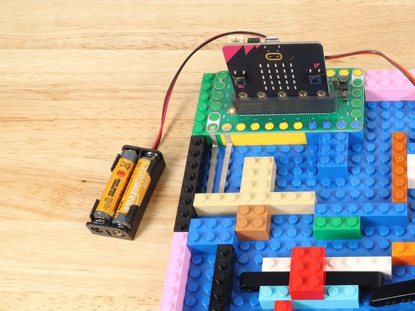 Use double-sided tape to attach the 2 AAA Battery Pack that comes with the Bit Board.