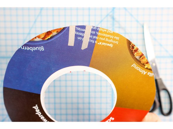 Stick two paths of maker tape to the cardboard. One will start on the back and go around the outside of the LED markers. The other will start about one inch from the first (also on the back) and go around the inside of the LED markers as shown.