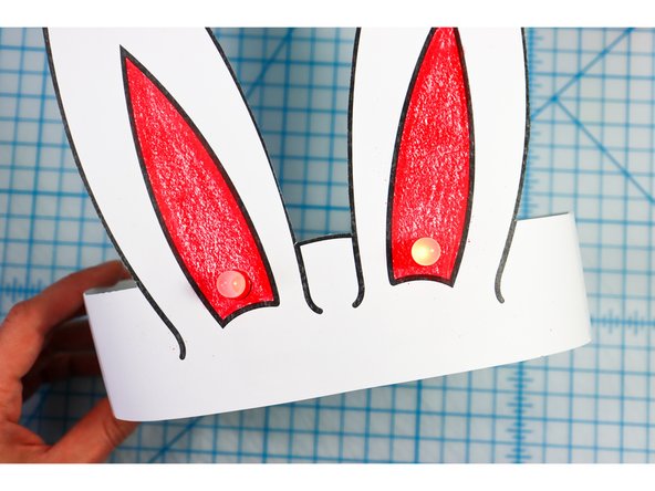 Cut out the side strips and tape them to the hat with the slits facing up on one side and down on the other.