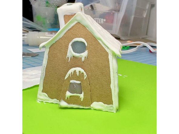 I made a tiny gingerbread house out of cardboard, with the chimney sized to fit the NeoPixels stick.