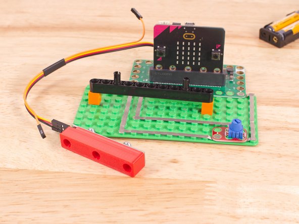 To mount the NeoPixel Stick in place we used our NeoPixel Beam Holder with a long Technic Beam and two 1x1 LEGO bricks.