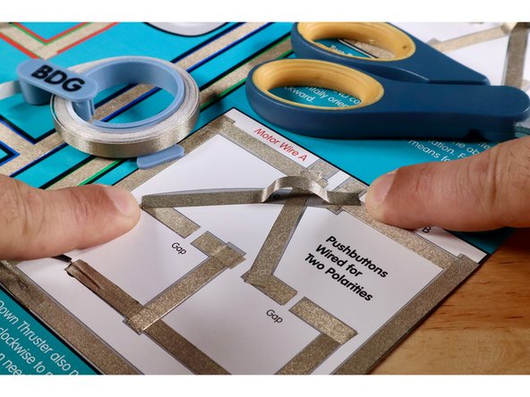 Measure, cut, peel, and stick the upper part of the criss-cross. This involves a jumped wire just like you saw in the Green and White LED/ROV Outcome paths. Use extra length to enable this path to cross over and above the lower part without touching it.