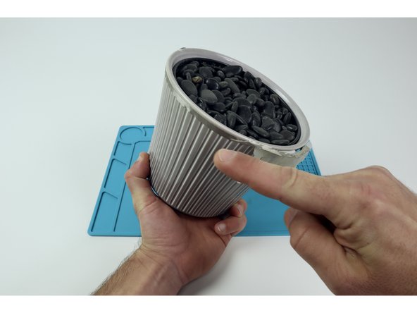 Once this separate Molded LED array  is prepared you will need to connect that top/negative path around the back of the flower pot where the battery is to be located. Afterward, snip a separate small piece of Maker Tape and with it make/stick a tape loop to the end of that path. Now, stick your battery to that tape loop positive side out.