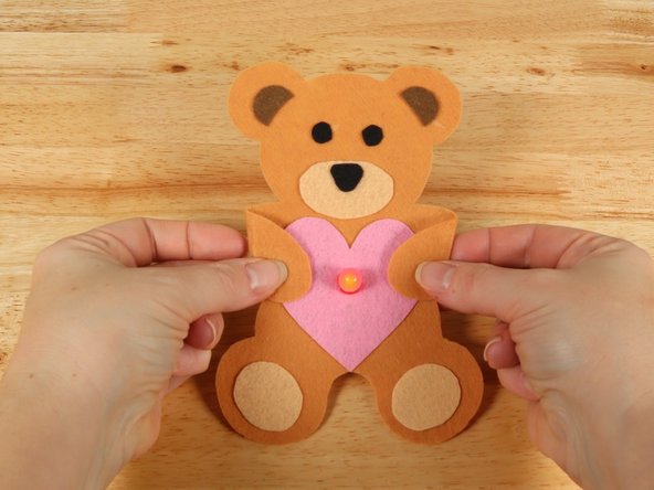 If you are using Elmers or Tacky glue, you will need to use something to hold the paws in place until it dries. Binder clips work well for this.