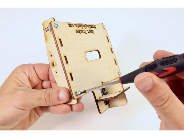 Fit the remaining side brace into the slots on the righthand side of the panel plate with the same orientation as the other. Use the remaining two screws and nuts to cinch that brace to the underside of the plate.