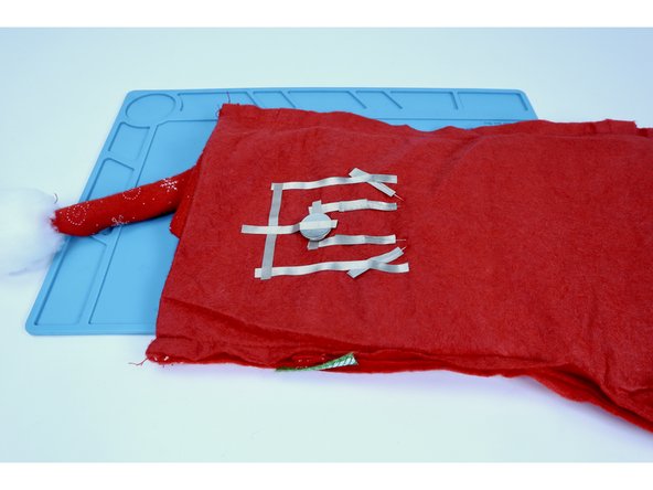 Measure, cut, peel and stick one final piece of Maker Tape that connects to the last tape segment you placed and the top of the battery. Once connected, your LEDs will both light up. Disconnecting this piece of Maker Tape will break the circuit and the lights will turn off.