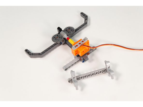 Grab the last LEGO Beam 11 and add 2 LEGO Cross Block Beam Bent 90 Degrees with 4 Pins . One at the end and one spaced one hole from the other end. (This will match the 10 hole wide frame of the Tank.)