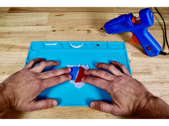 Press the mouth and face pieces into place atop the hot glue.