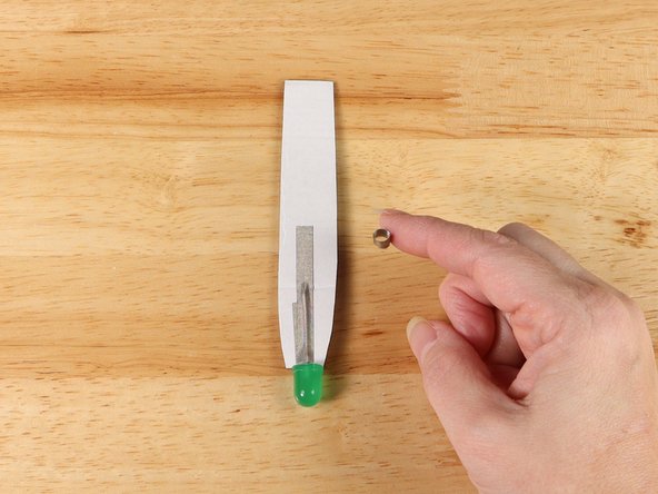 Make a loop of tape (sticky side out) using a short piece of Maker Tape, and stick it atop the end of the path coming from the short (Negative) LED leg.